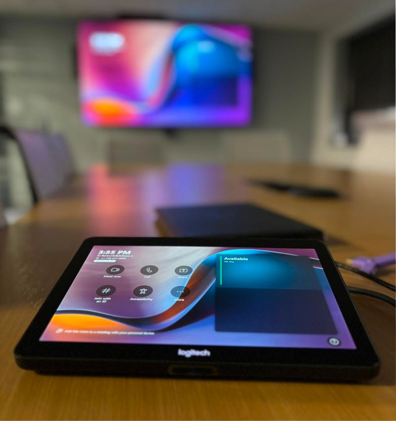 Logitech control panel with wall-mounted TV in a conference room