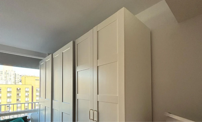 Side view of floor to ceiling white cabinet in an apartment