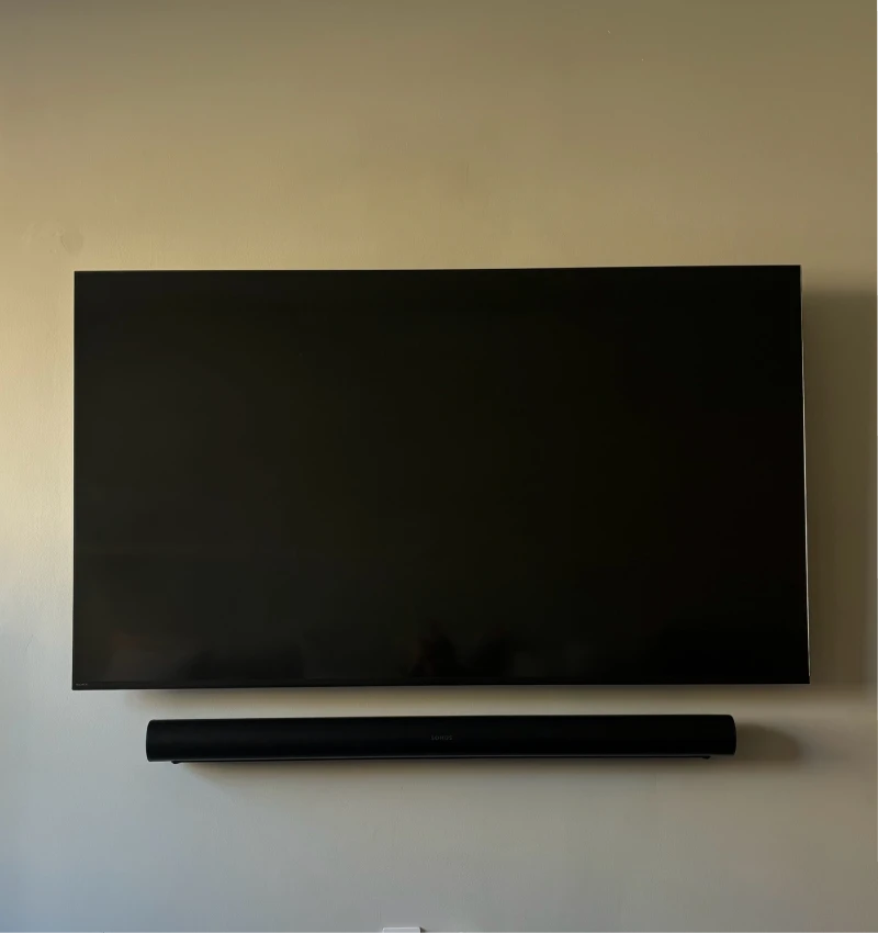 TV mounted on beige wall with soundbar installation