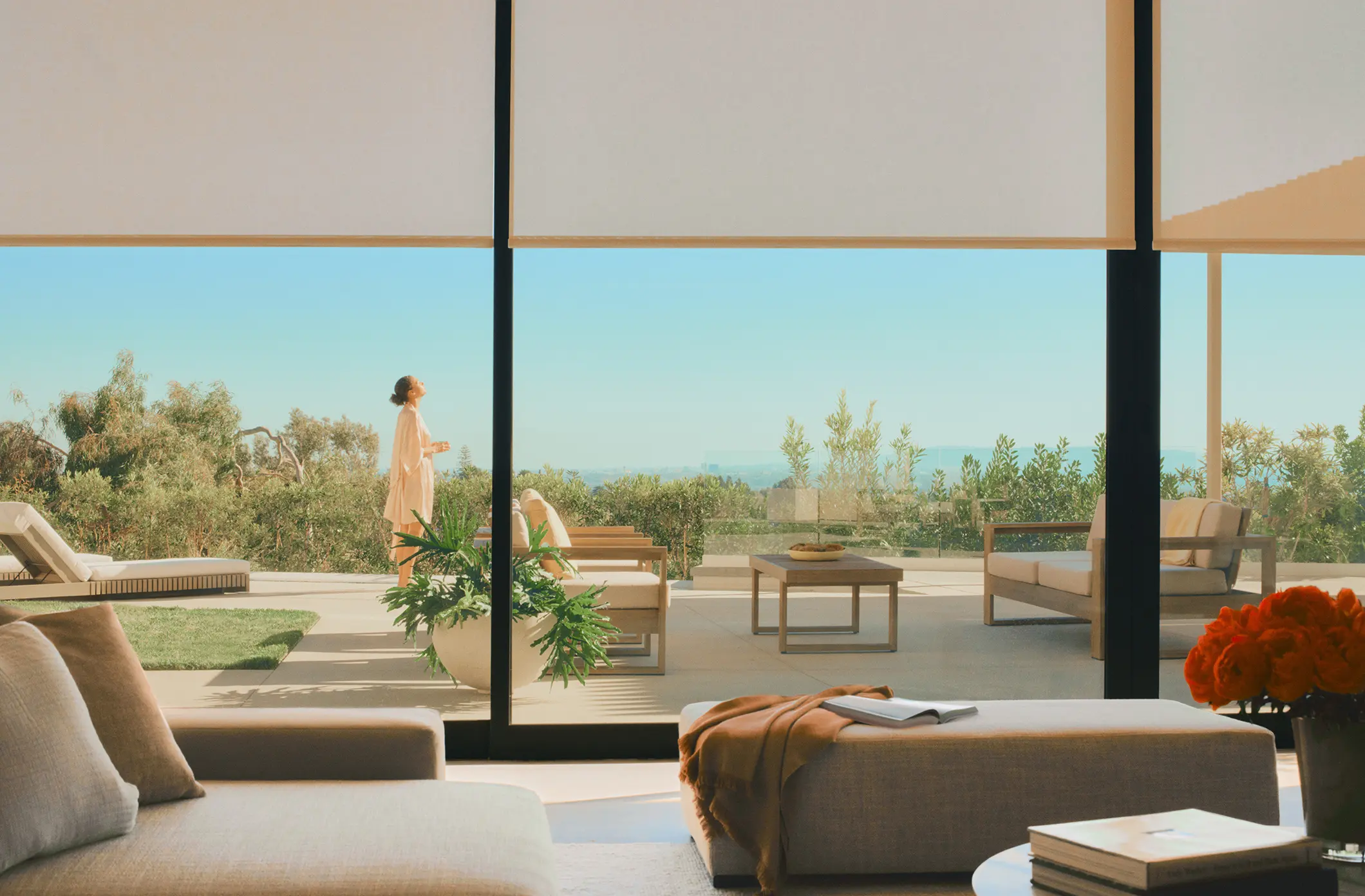 Young woman standing in a luxury patio in daylight through the window of a modern living room