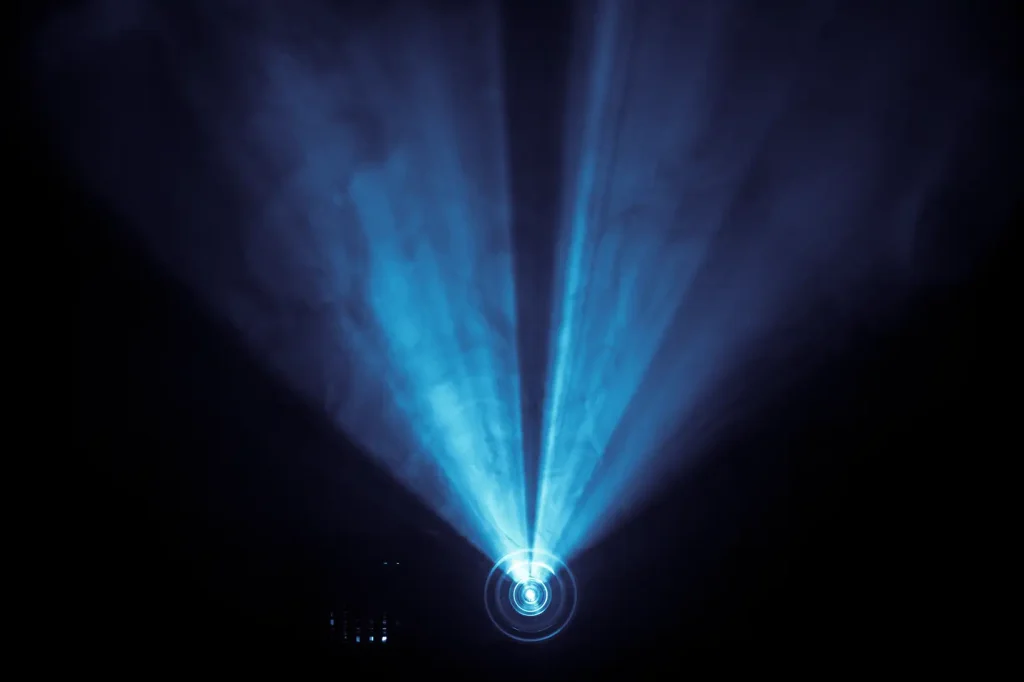 Projector vs TV: bright projector beam showing large display alternative to TV