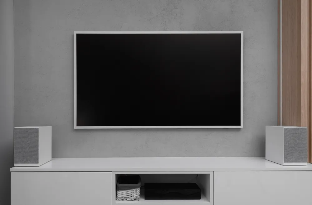 A modern flat-screen LCD TV hanging on the wall in the living room, a home theater system